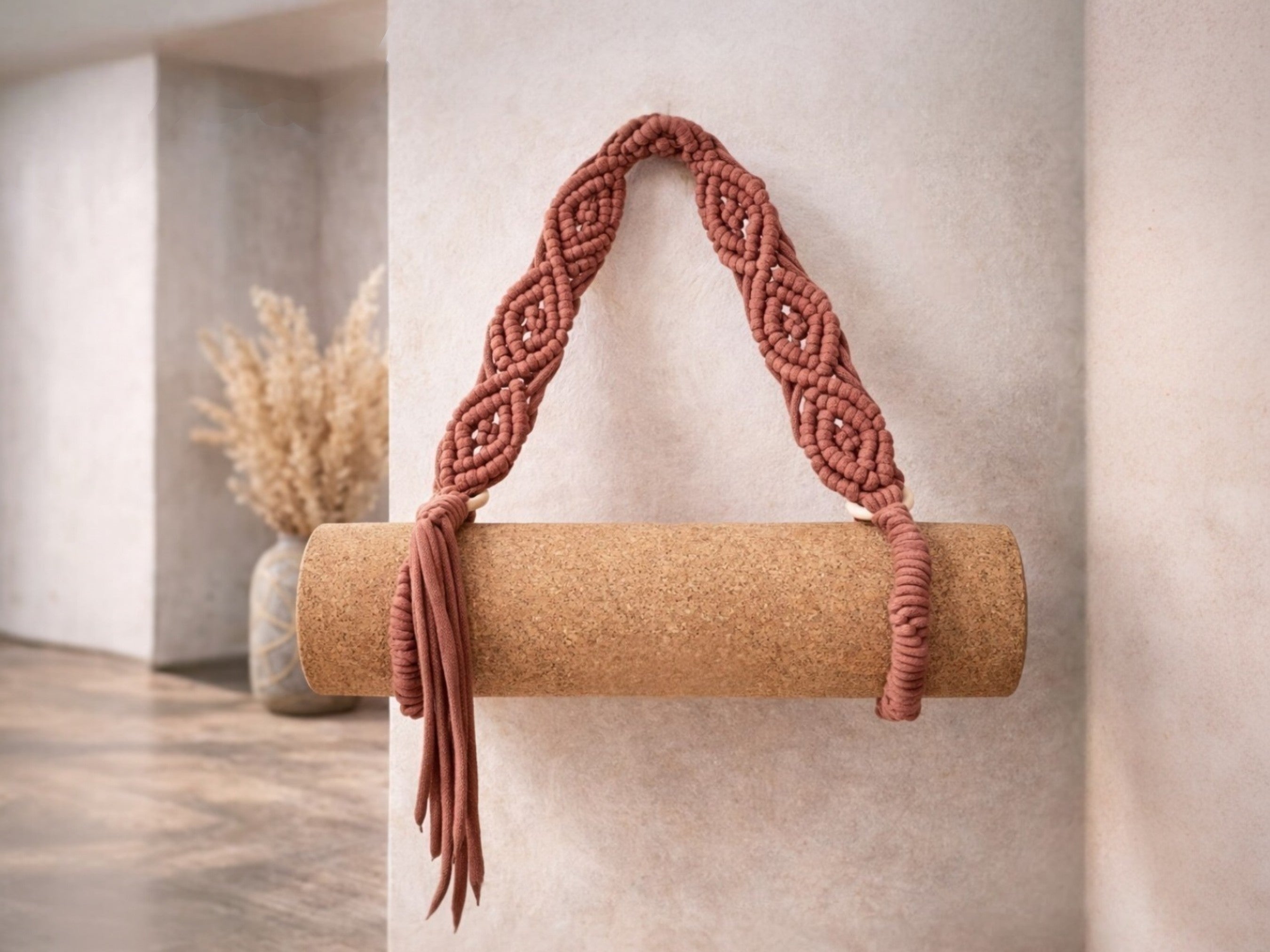 handbraided yoga mat strap bandha hanging on a wall with a hook