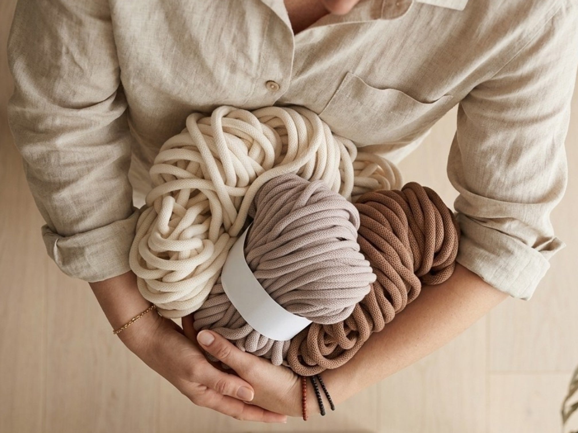 hands holding the cords of a kalarthe handbraided yoga mat strap