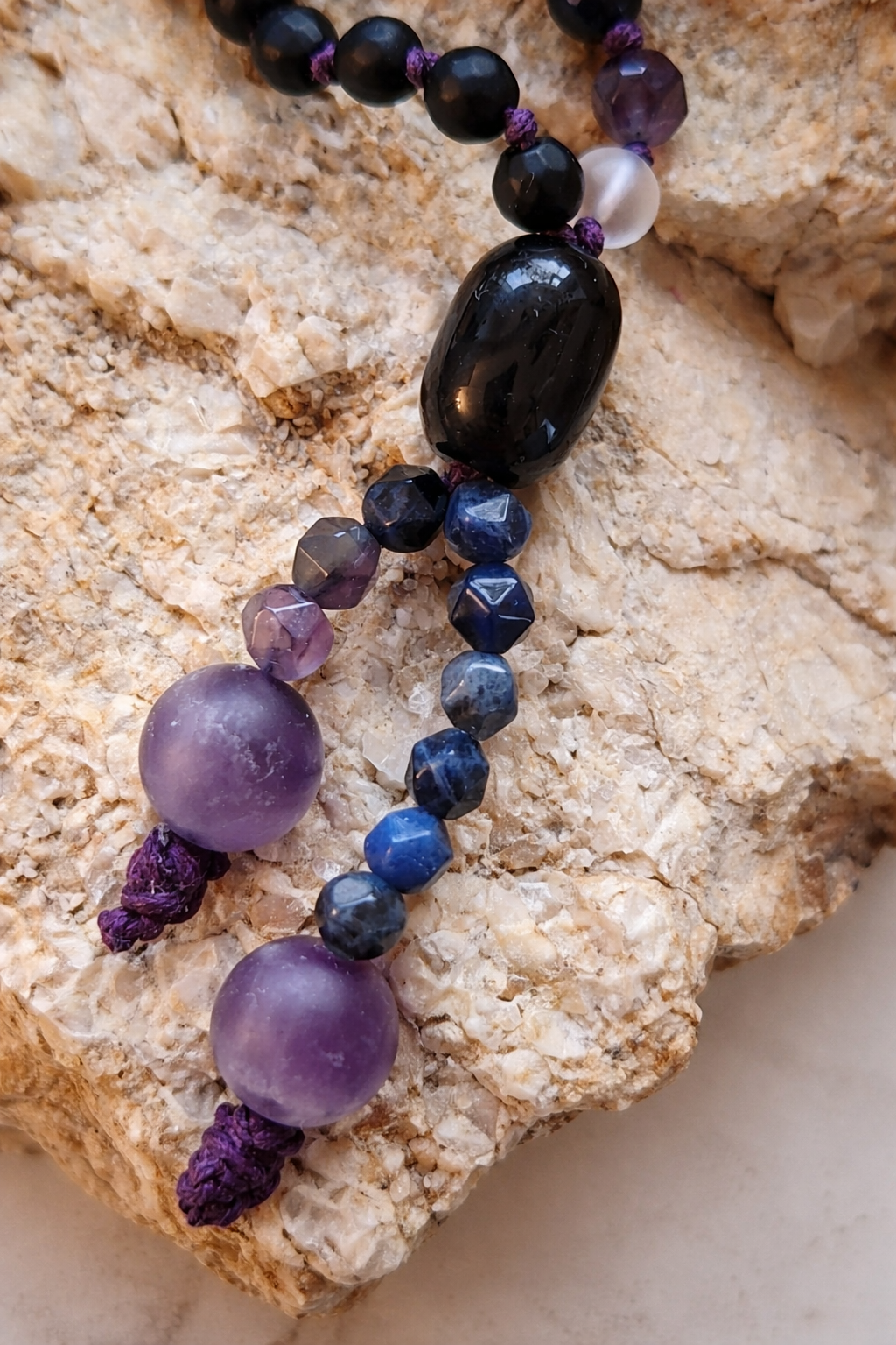 threshold mala — close-up of natural stone beads: onyx, lapis lazuli and clear quartz